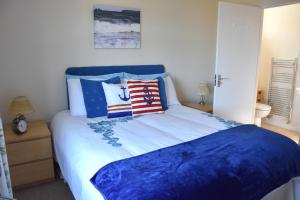 a bedroom with a large bed with blue sheets and pillows at Edens Horizon cottage annexe in St Austell