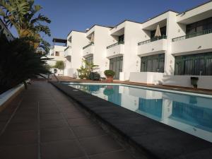 una piscina frente a un edificio en Apartamentos La Tegala en Puerto del Carmen