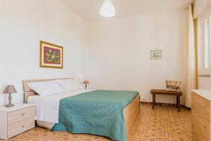 Dormitorio blanco con cama y mesa en Casa vacanze al mare, en Scicli