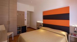 a bedroom with a bed with an orange and black headboard at Hotel Villa Gioiosa in Lido di Jesolo +47 photos
