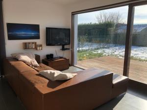 a living room with a couch and a large window at Sea-Senses.com in Koksijde