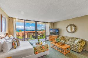 a living room with a couch and a large window at Kaanapali Shores Studio #742 in Lahaina