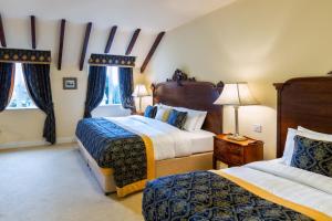 a hotel room with two beds and two windows at Earls Court House in Killarney