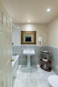 a bathroom with a sink and a toilet and a tub at Earls Court House in Killarney +50 photos
