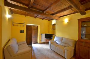 ein Wohnzimmer mit 2 Sofas und einem TV in der Unterkunft L'Elce in Orvieto
