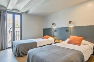 バルセロナにあるMy Address in Plaza Realのベッド2台と窓のある寝室