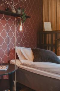 1 dormitorio con 1 cama y 1 mesa con lámpara en Bjäre Golfklubb Hotel & Lodge, en Båstad