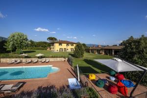 a pool with chairs and an umbrella and a house at Sant'Angelo Farmhouse in Bibbiena