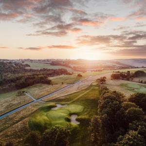 eine Luftansicht eines Golfplatzes mit Sonnenuntergang in der Unterkunft Bjäre Golfklubb Hotel & Lodge in Båstad
