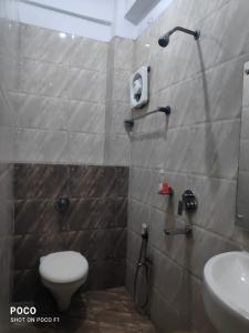 a bathroom with a shower with a toilet and a sink at HOTEL SUKHMANI in Guwahati