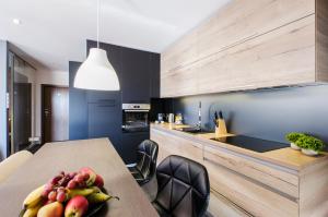 a kitchen with a table with a bowl of fruit on it at LupoApartments z Klimatyzacją do wyboru z Jacuzzi Pole Dance Parking Dostęp na Kod in Łódź