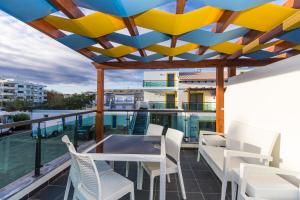 eine Terrasse mit einem Tisch und Stühlen auf dem Balkon in der Unterkunft Golden Maré BY ALGARVEMANTA in Manta Rota