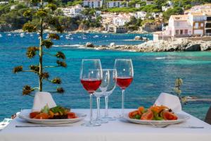 uma mesa com dois copos de vinho e um prato de comida em Hotel La Torre em Calella de Palafrugell