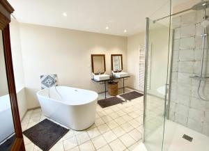 a bathroom with a tub and a glass shower at Domaine Les Mûriers in Brignoles