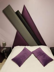 - une chambre avec un lit et des oreillers violets dans l'établissement Domaine de la Palle, à Pontgibaud