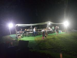 um grupo de pessoas debaixo de uma tenda à noite em Domaine de la Palle em Pontgibaud