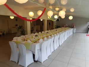 długi stół z białymi krzesłami i światłami w obiekcie Domaine de la Palle w mieście Pontgibaud