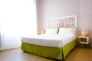 a bedroom with a large bed with a green frame at Myricae in Matera