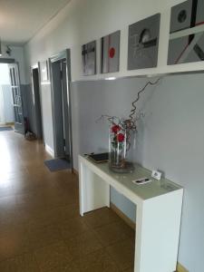 Una mesa blanca con un jarrón de flores. en Diepholzer–Boardinghouse en Diepholz