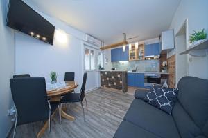 uma sala de estar com um sofá, uma mesa e uma cozinha em Apartment Alva em Splitska