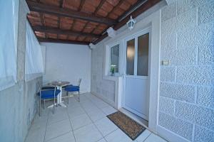 um pequeno quarto com uma porta, uma mesa e cadeiras em Apartment Alva em Splitska