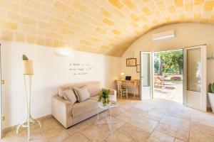 una sala de estar con un sofá y una mesa en Trullo con piscina baby, en San Michele Salentino 41 fotos más