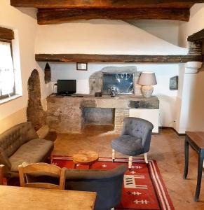 sala de estar con chimenea de piedra, sofá y sillas en Borgo Di Tragliata, en Tragliata