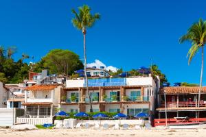 un hotel en la playa con palmeras y sombrillas en Pousada Bahia Bacana, en Morro de São Paulo