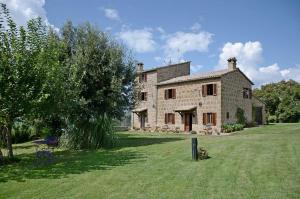 a large stone house with a grass yard at Podere Firenzuola in Orvieto