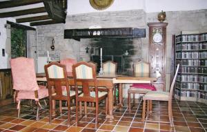 a dining room with a table and chairs and a clock at Crémoren Cottages in Scaër