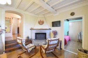 uma sala de estar com lareira e 2 cadeiras em Casa Silvia em San Casciano in Val di Pesa