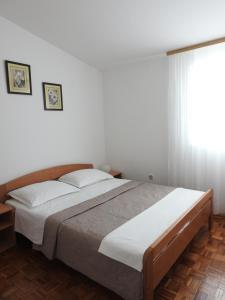 1 dormitorio con 1 cama grande y ventana en House Sušec, en Povljana