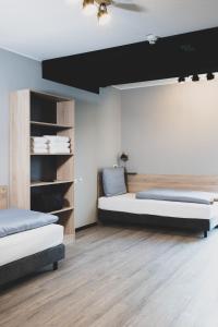 a bedroom with two beds and a tv on the wall at Das Schlafwerk Stuttgart-Nord VOLLDIGITALES HOTEL - Self-check-in -LowBudget in Korntal-Münchingen