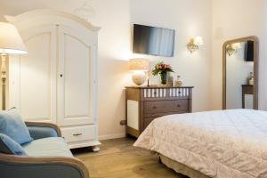 ローマにあるOne&Only Monti Suiteのベッドルーム(ベッド1台、椅子、テレビ付)