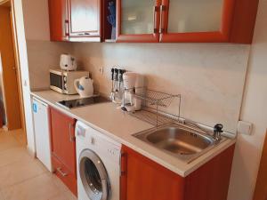 eine Küche mit einer Spüle und einer Waschmaschine in der Unterkunft Apartment Ashton Hall - Sonnenstrand – Ost in Sonnenstrand