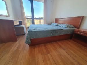 ein Schlafzimmer mit einem Bett und einem großen Fenster in der Unterkunft Apartment Ashton Hall - Sonnenstrand – Ost in Sonnenstrand