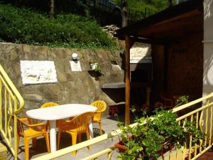 a patio with a table and chairs and a stone wall at Guest House Rusalka in Shipkovo