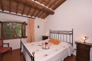 a bedroom with a bed and a chair and a window at Il Nocino in Castellina in Chianti