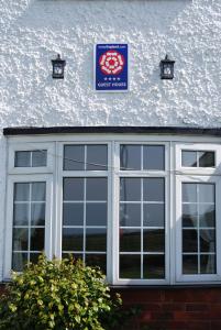 a sign on the side of a building with a window at The Ramblers in Trusthorpe