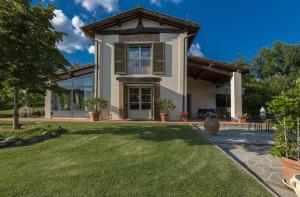 a house with a green lawn in front of it at Le Balze in Terranuova Bracciolini