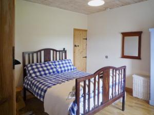 1 dormitorio con 1 cama con manta blanca y azul a cuadros en Cappacurry Lodge Ballinrobe, en Ballinrobe
