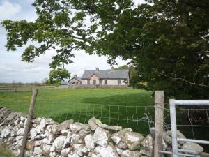 a fence in front of a house in a field at Cappacurry Lodge Ballinrobe in Ballinrobe