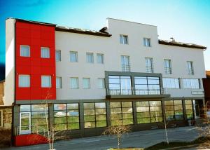 ein großes weißes Gebäude mit roten Türen und Fenstern in der Unterkunft Garni Hotel Crystal Ice in Niš