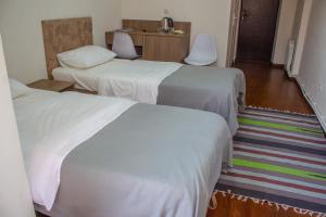 a hotel room with two beds and a desk at Chayka Hotel Ingushetia in Armkhi