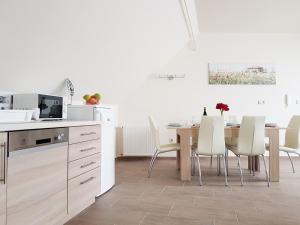 una cucina e una sala da pranzo con tavolo e sedie di Silver Lodge Apartman Eger a Eger