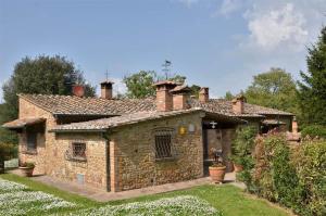 Una vieja casa de piedra con dos chimeneas encima. en Il Casolare, en Gambassi Terme