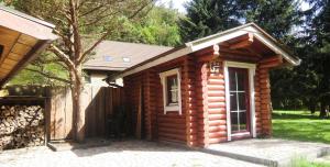 a log cabin with its door open in a yard at Haus am Wolfsbach Gruppenunterkunft in Zorge