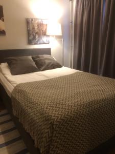 a large bed in a bedroom with a lamp at E-City B&B in Tornio