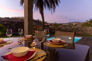 a table with wine glasses and a laptop on it at Salobre Golf Villa 3 Premium in Salobre