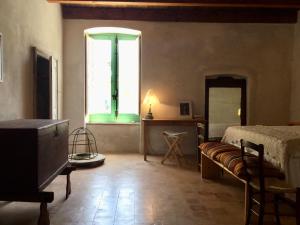 a living room with a bed and a window at BORGO PETELIA, Casa Centro, Antica abitazione calabrese con giardino, ristrutturata in Strongoli
